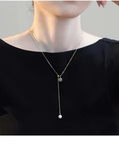 Elegant pearl and jade Y-necklace detail, silver chain, charming clavicle jewelry close up