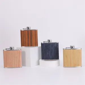 Detailed shot of portable stainless steel hip flasks with wood and bamboo texture finishes.