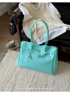 Mint green tote bag with metal lock hardware, spacious capacity, casual commuter style.