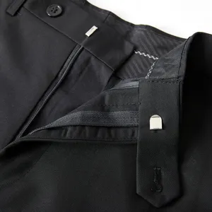 Detail shot of men's formal dress trousers showcasing the waistband, zipper, and button.
