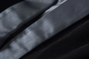 Velvet blazer fabric detail shot, premium black texture and smooth lining close up.