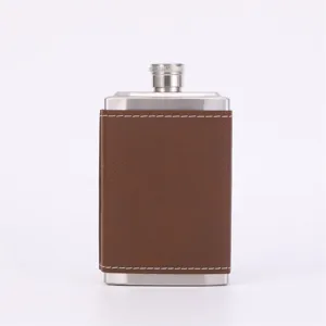 Close-up of brown leather wrapped stainless steel hip flask detail showcasing fine stitching.
