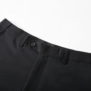 Close-up detail of men's black suit trousers waistband, showing fine fabric texture and button.