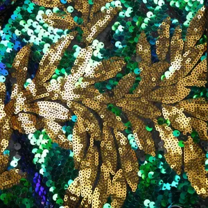 Nahaufnahme des luxuriösen Pailletten-Blattmuster-Stoffes mit glitzerndem Gold und Grün.