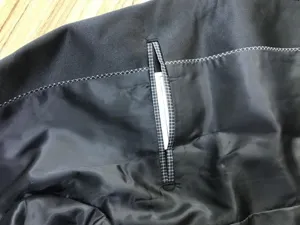 Detalle interior de chaqueta de traje elegante para hombre con forro negro y acabado de bolsillo.