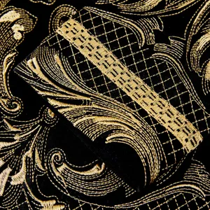 Luxury black velvet men blazer sleeve detail with intricate gold embroidery baroque design.