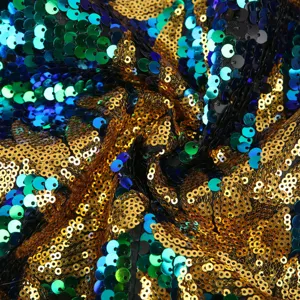 Detailansicht von buntem Paillettenstoff mit schimmernden goldigen, blauen und grünen Pailletten.