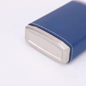 Close-up detail of stainless steel pocket hip flask with blue leather wrap and white stitching.