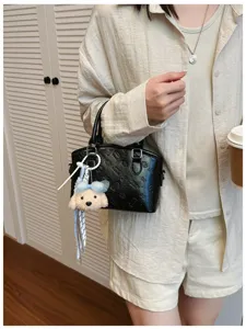 Women black top handle crossbody bag with cute puppy plush keychain, stylish fashion purse.