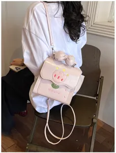 Vue détaillée du mini sac à dos rose brodé de tulipes avec nœud, sac de transport quotidien chic.