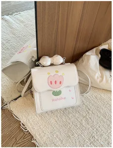 Gros plan détaillé du mini sac à dos blanc avec charmantes broderies de tulipes.