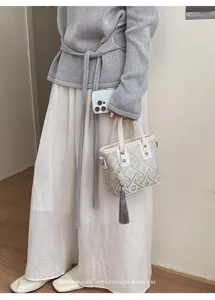 Detailansicht der chinesischen Retro-Handtasche mit geometrischem Muster und Quaste.
