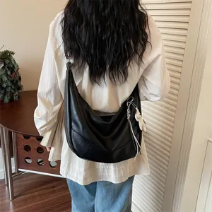 Detail view of a chic minimalist black slouchy shoulder bag, soft hobo style for women.