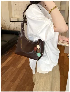 Minimalist brown underarm shoulder bag with beaded charm detail for women daily wear.