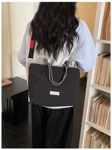 Casual large capacity black tote bag with rope handles and shoulder strap for daily commuting.