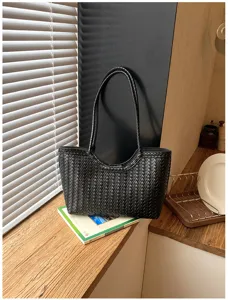 Detail view of the black woven leather tote bag showcasing premium intrecciato texture and daily design.