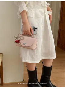 Trendy pink shoulder bag with pearl cherry charm, stylish square design for women.