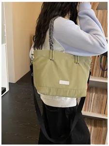Detail shot of the casual light green canvas tote bag with rope handles and crossbody strap.