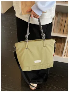 Detail view of casual canvas tote bag with rope handles, showing front label and strap.