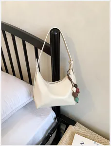 Minimalist hobo underarm bag detail shot, elegant solid color faux leather shoulder handbag.