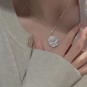Primo piano dettaglio di una collana in argento sterling opaco vintage con ciondolo a rosa.