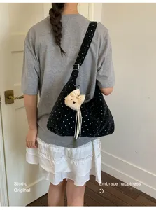 Detailed view of the cute polka dot shoulder bag with a charming bear pendant for sweet style.