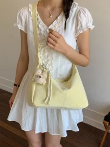 Cute polka dot shoulder bag for women, stylish underarm bag with plush bow pendant.