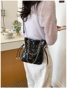 Black quilted chain bucket bag for women, stylish crossbody shoulder bag for daily commute.