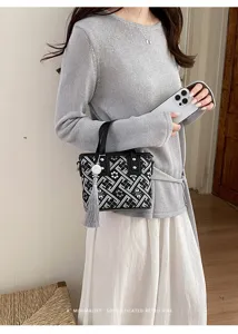 Details der neuen chinesischen geometrisch gemusterten Handtasche mit Quastenanhänger.