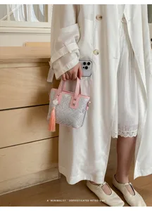 Detailansicht der neuen chinesischen Handtasche mit Jacquard-Muster und rosa Quasten-Anhänger.