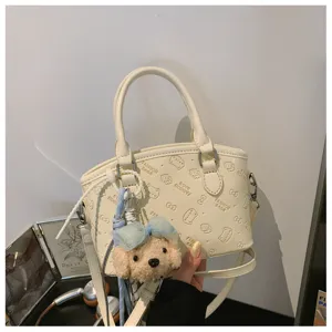 Japanese style white crossbody bucket bag with cute cartoon embossing and plush puppy pendant.