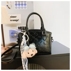 Black PU leather handbag with debossed cartoon pattern and cute plush puppy pendant.