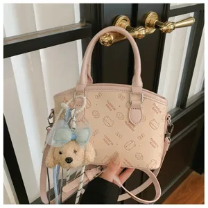 Pink PU leather crossbody shoulder bag with cute puppy plush pendant and fashion cartoon prints.