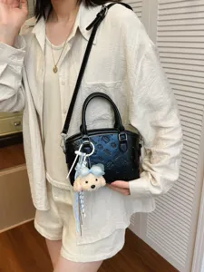 Black PU leather crossbody shoulder bag with cute plush dog pendant and embossed pattern.