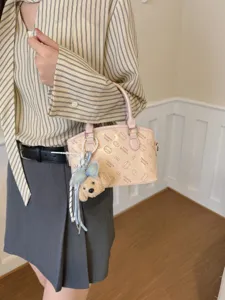 Cute pink cartoon print shoulder bag with plush pendant for women daily fashion style.