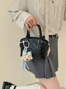 Chic black PU leather handbag with cute puppy pendant, stylish top-handle shoulder bag for women.