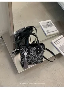 Detailansicht der schicken chinesischen geometrisch bestickten Handtasche mit Quastenanhänger.