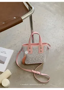 Nahaufnahme der neuen chinesischen Retro-Handtasche in Rosa und Grau mit Quastenanhänger.