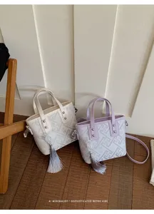 Nahaufnahme neuer chinesischer Mini-Handtaschen mit Retro-Geometriemustern und Quasten.