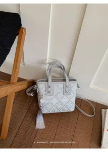 Detailansicht der Retro-Handtasche im chinesischen Stil mit geometrischem Muster und Quaste.