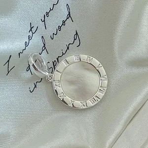 Nahaufnahme Detail eines S925 Sterling Silber Perlmutt Römische Ziffern Anhängers.