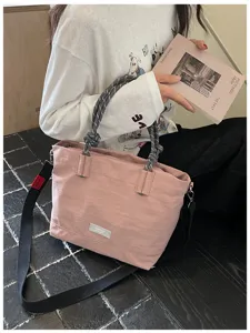 Casual large capacity tote bag detail view, pink fabric with rope handles and black strap.