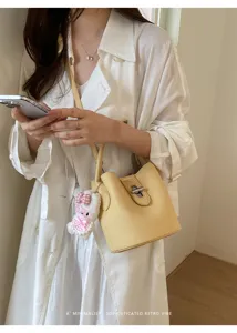Vue détaillée d'un sac seau jaune chic à grain litchi, élégante bandoulière pratique.