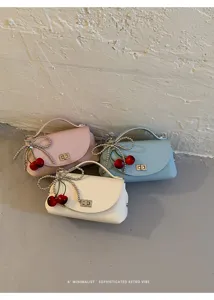 Detail view of chic women crossbody bags featuring pearl bow and cute cherry pendant decorations.