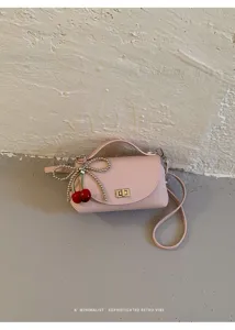 Minimalist retro pink crossbody bag with exquisite turn lock and sweet cherry charm detail.