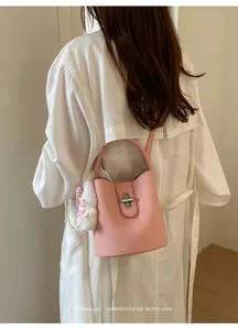 Sac seau en cuir rose pour femme, sac bandoulière rétro chic avec pendentif en peluche.