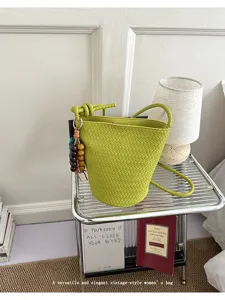 Detailed view of green woven bucket bag, vintage style single shoulder crossbody bag.