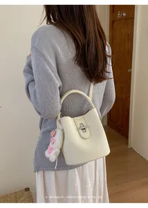 Sac seau rétro minimaliste pour femme en cuir grainé élégant avec poignée et bandoulière chic.