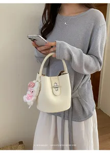 Vue détaillée du sac seau tendance pour femme en cuir synthétique avec pendentif lapin en peluche.