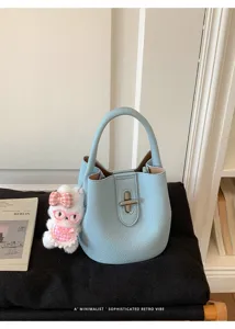 Sac seau bleu clair élégant avec charm lapin mignon et fermeture tourniquet sophistiquée.